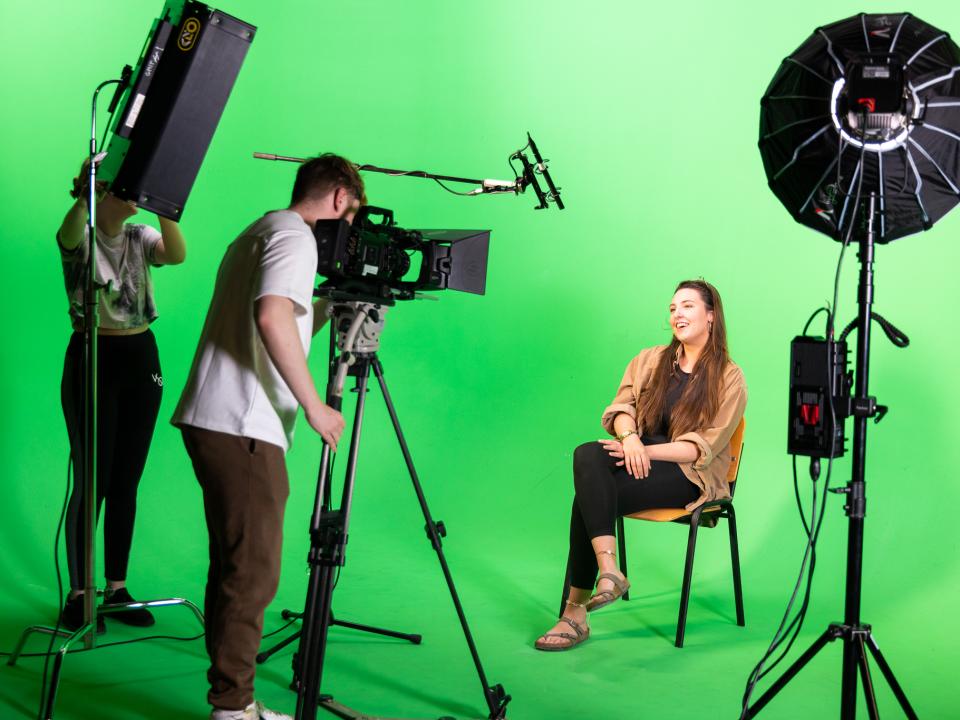 Students working at a green screen 